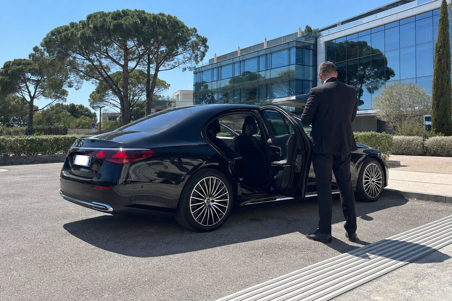 Mercedes Classe E noire à disposition d’une entreprise devant un immeuble de bureaux moderne de la technopole de Sophia Antipolis, chauffeur privé BSM