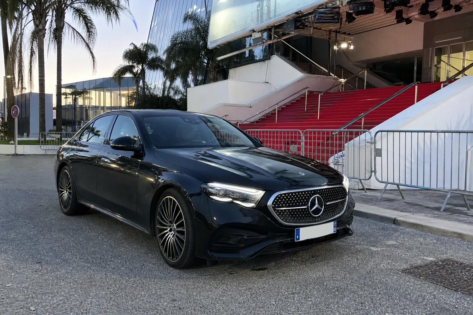 Mercedes Classe E noire devant le Palais des Festivals à Cannes, tapis rouge déroulé — chauffeur événementiel Festival de Cannes